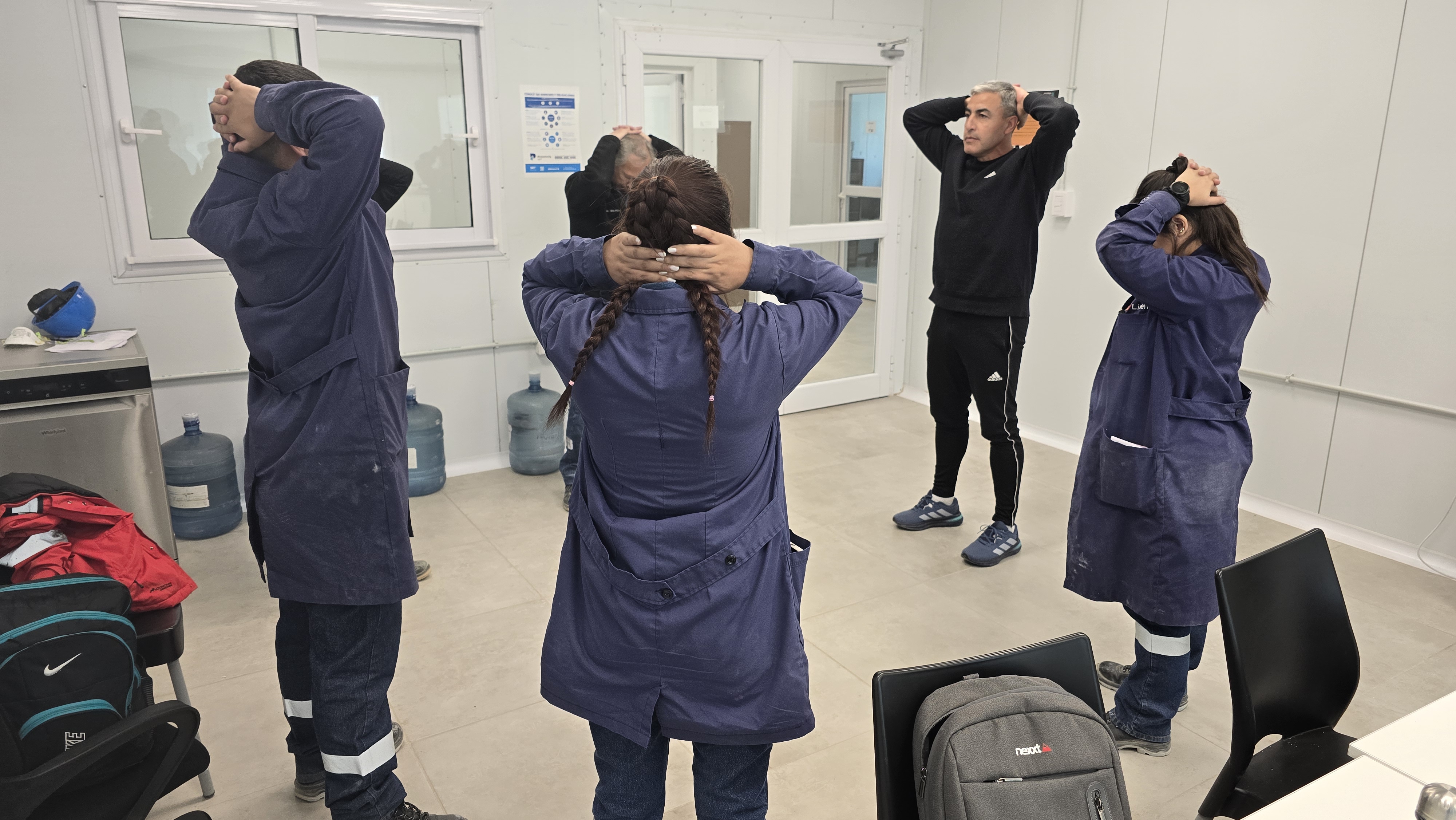 Equipo de trabajadores realizando ejercicios de estiramiento y pausa activa con Victor Cuellar